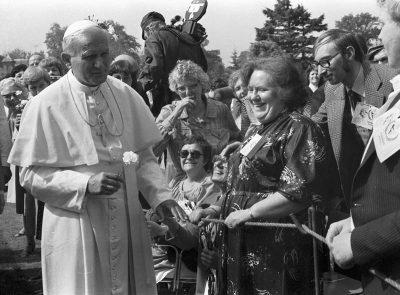 A local woman gives Pope John Paul II a flower at St Joseph's hospital, in Rosewell.