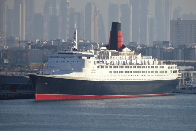 Ocean liners were no longer built solely with transport in mind by the time of the Queen Mary’s retiral. Instead they were marketed as holiday destinations in their own right. The age of luxury cruises arrived at just the right time for the Queen Elizabeth 2 - or the QE2 as she quickly became known. She was the last superliner to be built at John Brown’s yard in Clydebank and many Scots can still recall her launch in September 1967. The interior and superstructure of the ship was designed by James Gardner - described by the Council of Industrial Design as that of a “very big yacht”. The QE2 would serve as the Cunard line’s flagship from 1969 until the launch of the French-built Queen Mary 2 in 2004. Although she spent much of her life as a crusie ship, the QE2 did undertake scheduled sailings from Southhampton to New York each year - a tradition continued by the Queen Mary 2. The liner was retired in 2008 and sold to an investment consortium.