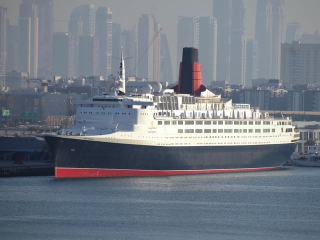 Ocean liners were no longer built solely with transport in mind by the time of the Queen Mary’s retiral. Instead they were marketed as holiday destinations in their own right. The age of luxury cruises arrived at just the right time for the Queen Elizabeth 2 - or the QE2 as she quickly became known. She was the last superliner to be built at John Brown’s yard in Clydebank and many Scots can still recall her launch in September 1967. The interior and superstructure of the ship was designed by James Gardner - described by the Council of Industrial Design as that of a “very big yacht”. The QE2 would serve as the Cunard line’s flagship from 1969 until the launch of the French-built Queen Mary 2 in 2004. Although she spent much of her life as a crusie ship, the QE2 did undertake scheduled sailings from Southhampton to New York each year - a tradition continued by the Queen Mary 2. The liner was retired in 2008 and sold to an investment consortium.
