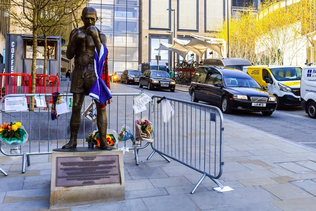 The funeral procession of legendary Scottish boxing world champion Ken Buchanan MBE  passes the Ken Buchanan statue ahead of a memorial service