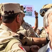 Protesters raise signs in solidarity with Palestinians in the Gaza Strip as Egyptian army officers and bodyguards escort United Nations Secretary-General Antonio Guterres to his vehicle (Image: KEROLOS SALAH/AFP via Getty Images)