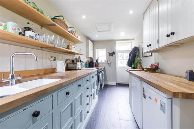 The modern Shaker-style kitchen includes a range cooker and a door out to the garden