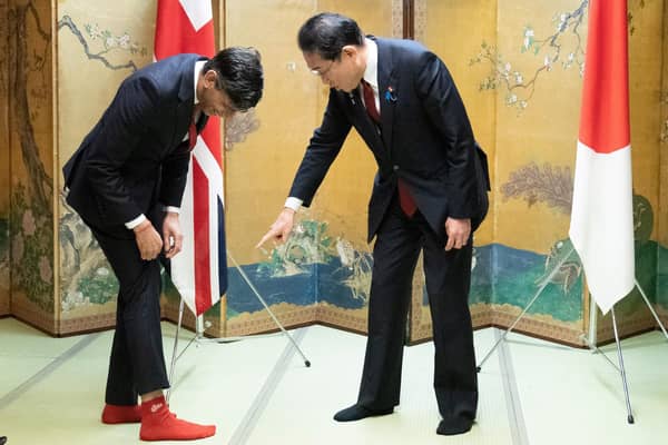 Prime Minister Rishi Sunak shows off his socks to Japanese Prime Minister Fumio Kishida, which has the name of Kishida's favorite baseball team, Hiroshima Toyo Carp. on them. Picture: Stefan Rousseau/AFP via Getty Images