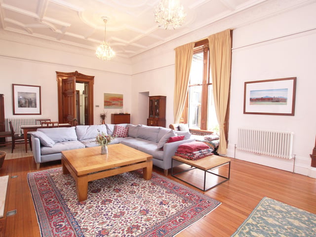 Interior: Generous rooms boast high ceilings and plenty of rich period features, including stained glass. It has a dual-aspect lounge with focal-point fireplace, a dining-kitchen, and a double bedroom plus ensuite.