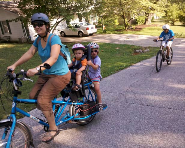 A mum cycles with her two kids on the back. IF we all made such an effort with our young ones, the world would be a better - and cleaner - place, writes Hayley Matthews. PIC: Flickr/Mark Stosberg.
