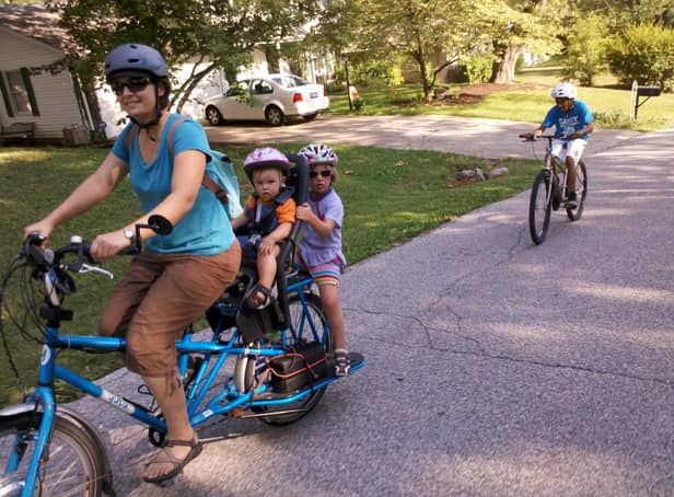 A mum cycles with her two kids on the back. IF we all made such an effort with our young ones, the world would be a better - and cleaner - place, writes Hayley Matthews. PIC: Flickr/Mark Stosberg.