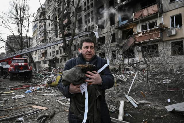 A man holds his dead cat in a blanket as he stands outside a block of flats in Kyiv after it was shelled by Russian forces yesterday (Picture: Aris Messinis/AFP via Getty Images)