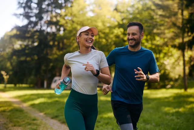 Happy athletic couple having fun while running together.