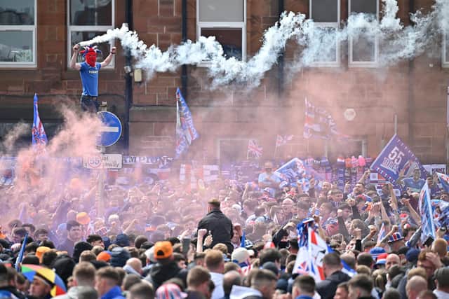 Fans celebrate winning the Scottish Premiership title outside the Ibrox Stadium on May 15, 2021 in Glasgow, Scotland. Rangers have won their first Scottish Premiership title in a decade with former Liverpool midfielder Steven Gerrard at the helm. Football fans are currently unable to attend matches due to coronavirus restrictions, with the club urging fans to celebrate in a "safe and sensible manner". (Photo by Jeff J Mitchell/Getty Images)