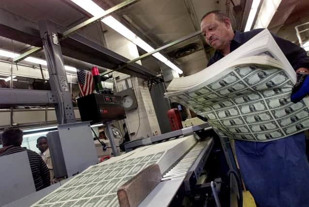 Newly printed dollar bills are prepared for cutting at a US Bureau of Printing and Engraving plant in Washington (Picture: Hillery Smith Garrison/AP/file)