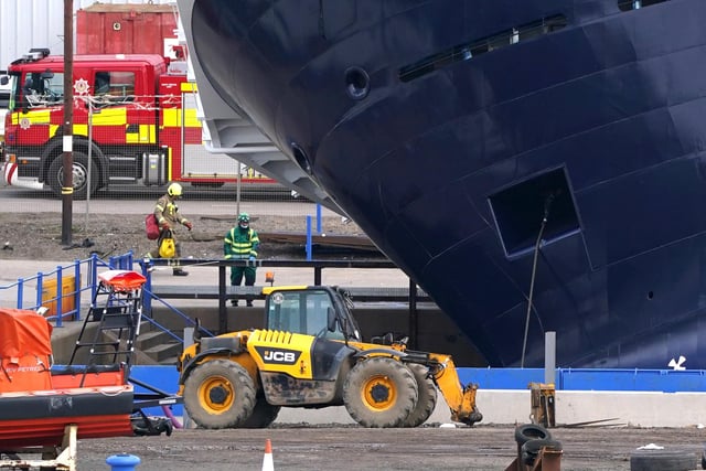 Emergency services at Imperial Dock in Leith, Edinburgh, where a ship has become dislodged from its holding and is partially toppled over.