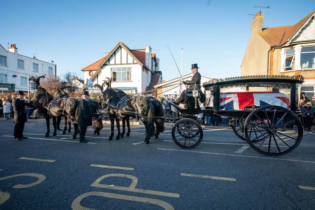 Members of the public pay their respects as the horse drawn hearse carrying the coffin of Sir David Amess, arrives at his constituency office at Iveagh Hall, in Leigh-on-Sea, following his funeral service. Picture: Aaron Chown/PA Wire