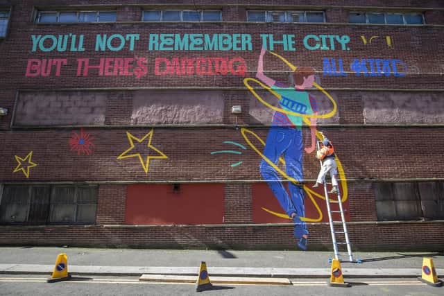 Glasgow School of Art graduate Chelsea Frew, one of the Cobolt Collective illustrators, works on part of the Shuggie Bain mural outside the Barrowland Ballroom in the east end of Glasgow.