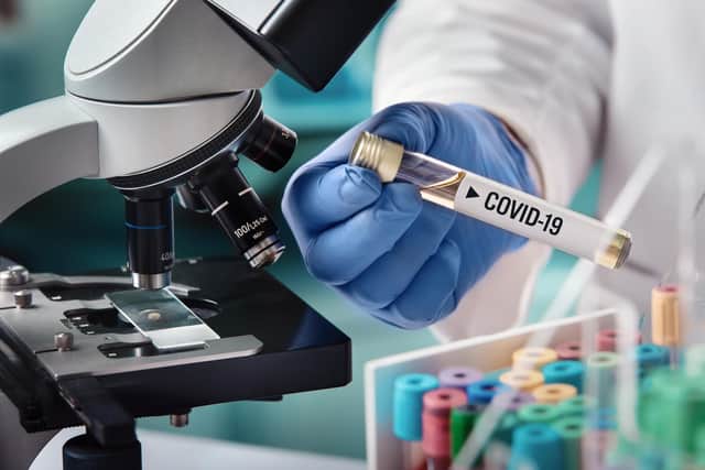A microbiologist with a tube containing a sample contaminated with Covid-19. Pic: angellodeco-shutterstock
