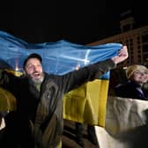 A man holds a Ukranian flag as people gather in Maidan Square to celebrate the liberation of Kherson, in Kyiv on November 11, 2022, amid the Russian invasion of Ukraine.