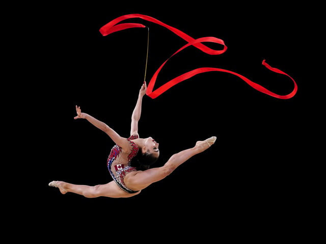 Amid a hectic Commonwealth Games in Birmingham, Mike Egerton caught an unusually serene image of rhythmic gymnast Suzanna Shahbazian competing.
“Most of the time sports photography is all about capturing that dramatic moment, but the thing I like most about this shot is its simplicity and grace,” Mike said.
“I had a small gap between two television cameras where I had to hope the gymnast jumped so that the background was kept clean. I got lucky with this shot as she jumped in just the right spot and luckily the ribbons were captured at just the right moment.”