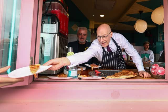 First Minister John Swinney reckons decisions served up in Scotland are bound to be better than Westminster fare; SNP candidate Tommy Sheppard can be seen behind him (Picture: Jeff J Mitchell/Getty Images)