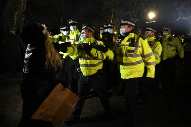 LONDON, ENGLAND - MARCH 13: Police Officers arrest a woman during a vigil on Clapham Common, where floral tributes have been placed for Sarah Everard. Picture: Leon Neal/Getty Images