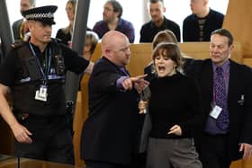 Police and security staff escort a protester from the public gallery during First Minister's Questions. Picture: Jeff J Mitchell/Getty Images