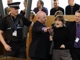 Police and security staff escort a protester from the public gallery during First Minister's Questions. Picture: Jeff J Mitchell/Getty Images