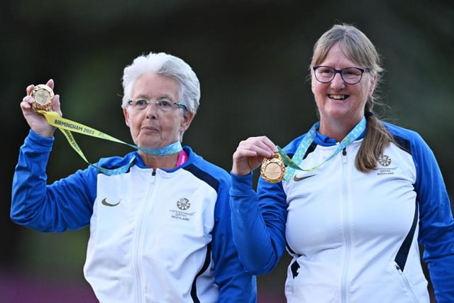 Gold medalists Rosemary Lenton and Pauline Wilson of Team Scotland pose on the podium during lawn bowls Para Women's Pairs B6-B8 medal ceremony.