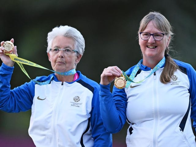 Gold medalists Rosemary Lenton and Pauline Wilson of Team Scotland pose on the podium during lawn bowls Para Women's Pairs B6-B8 medal ceremony.
