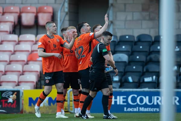 Referee Nick Walsh picks up a glass bottle that had been thrown onto the pitch as Dundee United's Tony Watt (arm raised) was celebrating scoring in front of the Raith Rovers fans   (Photo by Ewan Bootman / SNS Group)