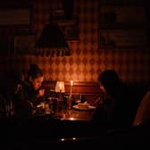 This photograph, taken in October 2022, shows visitors eating lunch by candlelight due to a power cut at a bar in the centre of the Ukrainian capital of Kyiv. Picture: Sergei Supinsky/AFP via Getty Images