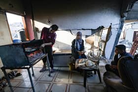 Family members prepare traditional unleavened bread in their destroyed house in Rafah in the southern Gaza Strip. The World Health Organisation has warned 93 per cent of the population have hit a crisis level of hunger.