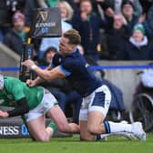 Mack Hansen of Ireland scores the team's first try whilst under pressure from Duhan van der Merwe of Scotland.