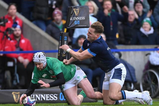 Mack Hansen of Ireland scores the team's first try whilst under pressure from Duhan van der Merwe of Scotland.