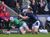 Mack Hansen of Ireland scores the team's first try whilst under pressure from Duhan van der Merwe of Scotland.