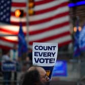 A protester holds a placard that reads "Count Every Vote" while demonstrating across the street from supporters of Donald Trump outside an election count in Philadelphia, Pennsylvania (Picture: Mark Makela/Getty Images)