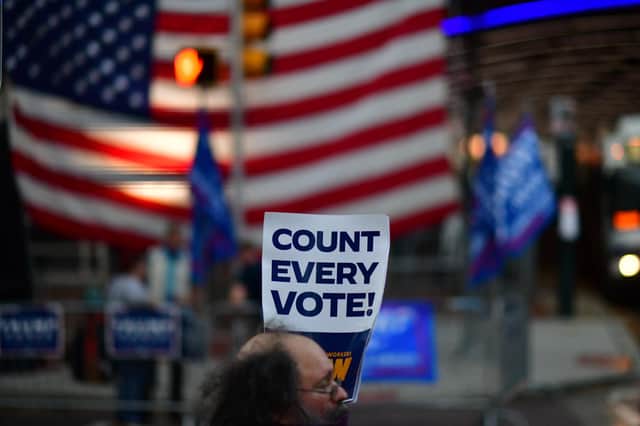 A protester holds a placard that reads "Count Every Vote" while demonstrating across the street from supporters of Donald Trump outside an election count in Philadelphia, Pennsylvania (Picture: Mark Makela/Getty Images)