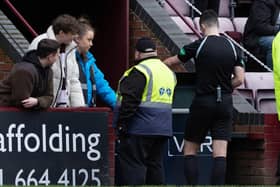 Referee Don Robertson checks the VAR monitor for a handball by Celtic's Tomoki Iwata.