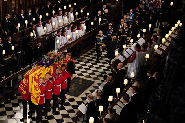 The coffin of Queen Elizabeth II, followed by (left to right, from front) King Charles III, the Queen Consort, the Princess Royal, Vice Admiral Sir Tim Laurence, the Duke of York, the Earl of Wessex, the Countess of Wessex, the Prince of Wales, Prince George, Princess Charlotte, the Princess of Wales, the Duke of Sussex, the Duchess of Sussex, Peter Phillips, the Earl of Snowdon, the Duke of Gloucester, the Duke of Kent, and Prince Michael of Kent, is carried by the Bearer Party in to the Committal Service at St George's Chapel in Windsor Castle, Berkshire.