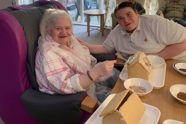 HC-One Scotland’s Ballumbie Court Care Home’s Wellbeing Coordinator Margaret (better known as Maggie) Pryde with resident Karen Whitefield making a Gingerbread House for Gingerbread Day
