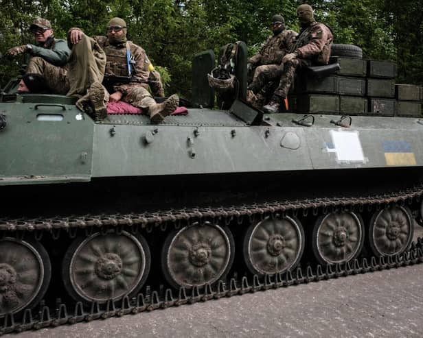 Ukrainian soldiers ride on a light armored multi-purpose towing vehicle near Bakhmut, eastern Ukraine, on May 15, 2022, amid the Russian invasion of Ukraine. (Photo by Yasuyoshi Chiba via Getty Images)