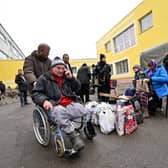 A rescuer assists a disabled man after he was evacuated from the city of Irpin to the outskirts of Ukrainian capital Kyiv last month