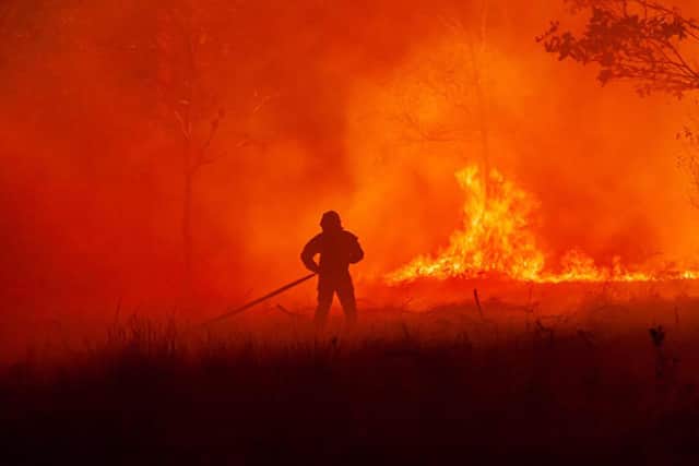 A firefighter battles a wildfire near the village of Saumos, southwestern France, in September last year (Picture: SDIS33 fire brigade via AP)
