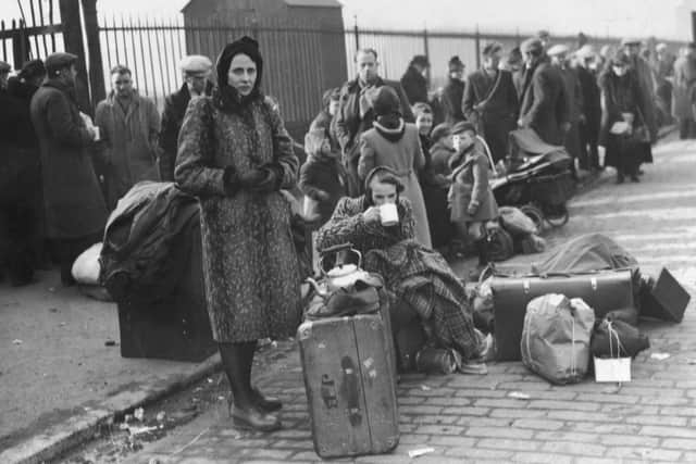 People stand in the street with their belongings after a severe bombing raid destroyed many homes on Clydeside in 1941 (Picture: Keystone/Hulton Archive/Getty Images)