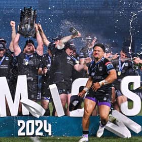 Zander Fagerson lifts the URC trophy as Sione Tuipulotu is soaked with champagne after Glasgow Warriors' victory over the Bulls at Loftus Versfeld. (Photo by Anton Geyser/SNS Group)