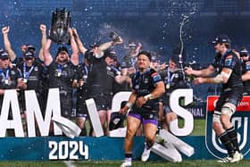 Zander Fagerson lifts the URC trophy as Sione Tuipulotu is soaked with champagne after Glasgow Warriors' victory over the Bulls at Loftus Versfeld. (Photo by Anton Geyser/SNS Group)