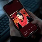 A woman looks at a picture of former Afghan lawmaker Mursal Nabizada on her mobile phone, who was shot dead by gunmen at her house in Kabul. Picture: AFP via Getty Images