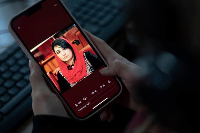 A woman looks at a picture of former Afghan lawmaker Mursal Nabizada on her mobile phone, who was shot dead by gunmen at her house in Kabul. Picture: AFP via Getty Images