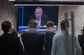 Staff in the green room watching a television screen showing presenter Andrew Neil broadcast from a studio, during the launch event for new TV channel GB News.
