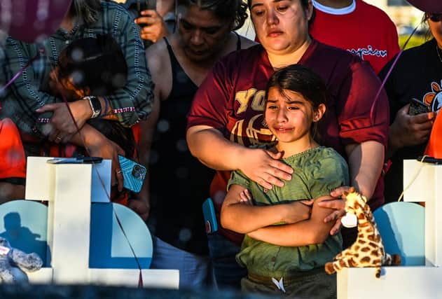 Gabriella Uriegas, whose friend Tess Mata died in the shooting at Robb Elementary School, cries while her mother Geneva Uriegas holds her at makeshift memorial outside the Uvalde County Courthouse in Texas (Picture: Chandan Khanna/AFP via Getty Images)