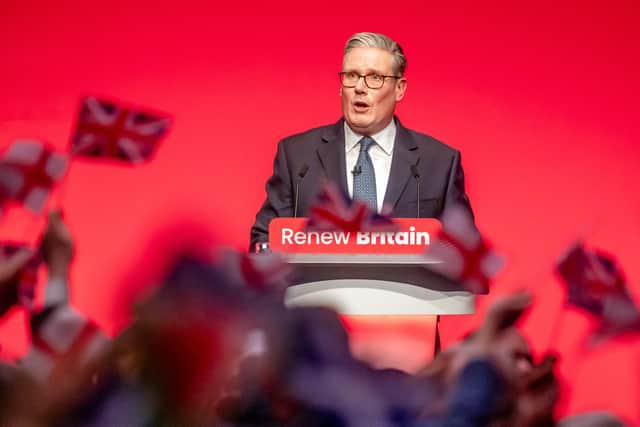 People wave flags as Prime Minister Sir Keir Starmer delivers his keynote speech during the Labour Party Conference. PIC: Danny Lawson/PA Wire