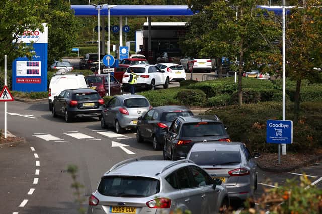 Vehicles queue to fill up at a petrol station as panic-buying takes hold. Photo by ADRIAN DENNIS/AFP via Getty Images