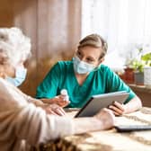 A staff member speaks with a resident at a care home